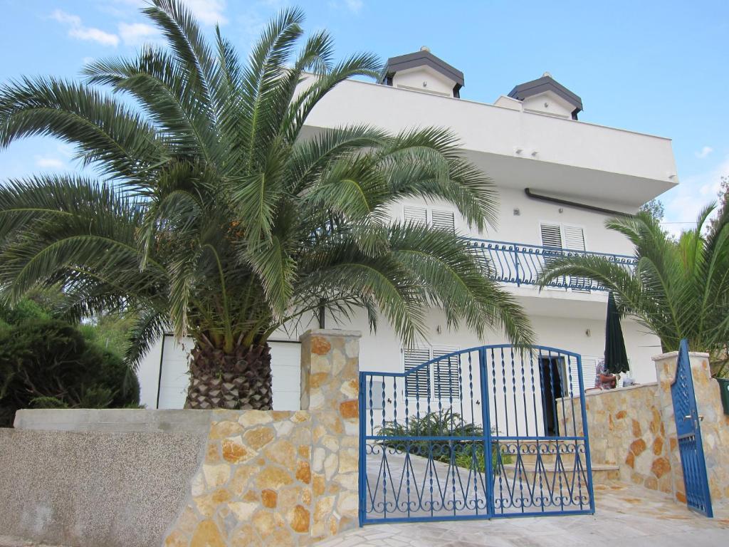 a palm tree in front of a white building at Apartment 2 Palme in Slatine