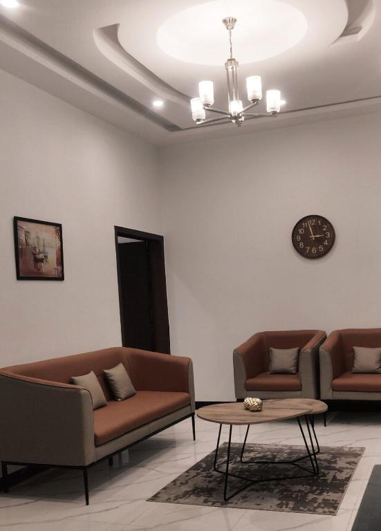 a living room with two couches and a table at Luxury Apartment Cozy & Peace-full View in Murree