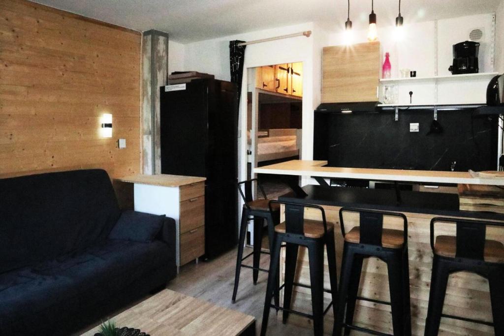 - un salon avec un canapé et une table avec des tabourets dans l'établissement Résidence L'oustal - Joli studio 4 personnes MAE-2774, aux Orres