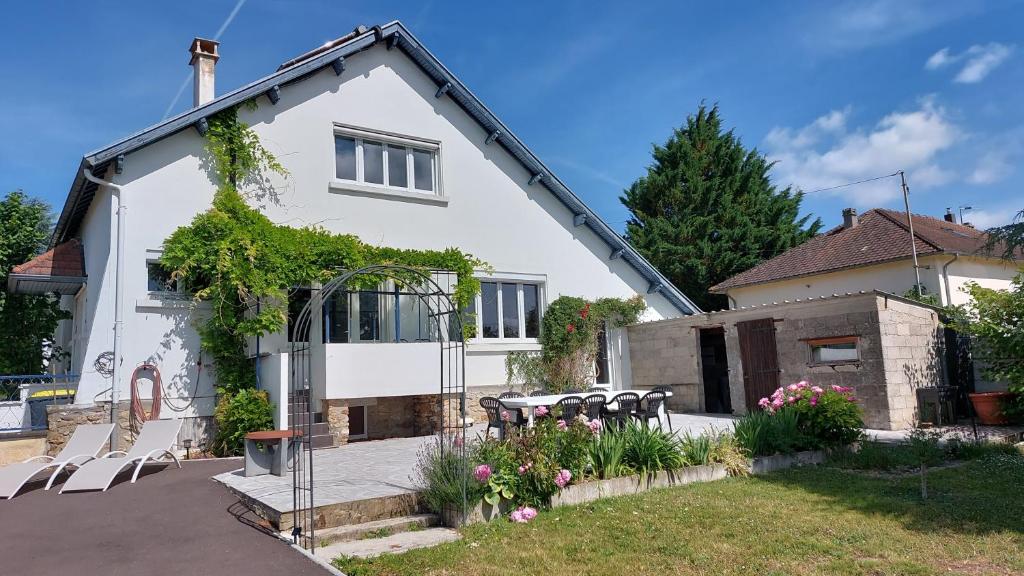 une maison blanche avec une table et des chaises dans une cour dans l'établissement L'ABulle glanoise, à Gland