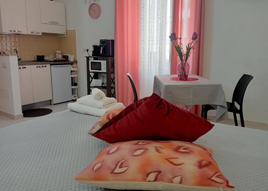 a room with a table with two pillows on a bed at San Giovanni Apartment in Catanzaro