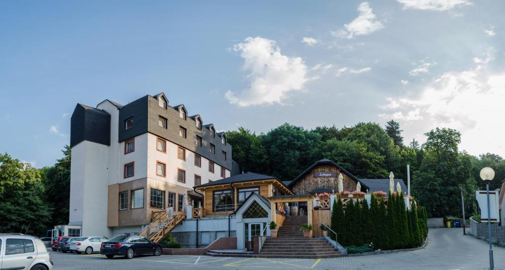 un gran edificio con una casa en un estacionamiento en Hotel West en Bratislava