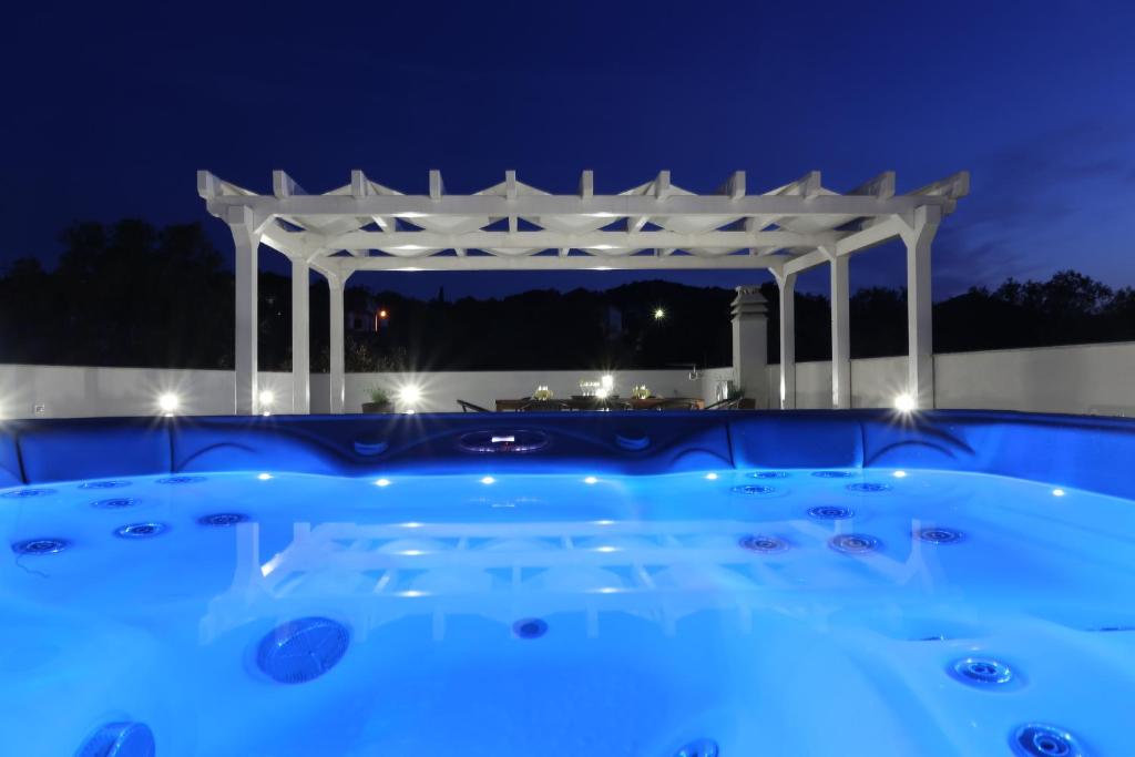 ein Schwimmbad mit einer Pergola in der Nacht in der Unterkunft Villa Tea in Zadar