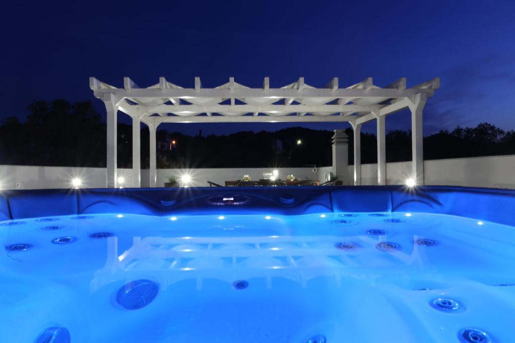 a swimming pool with a pergola at night at Villa Tea in Zadar