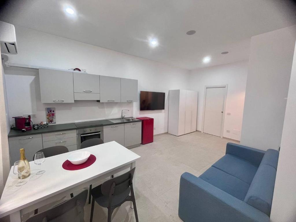a kitchen with a blue chair and a white table at Giannina House 22 in Cefalù