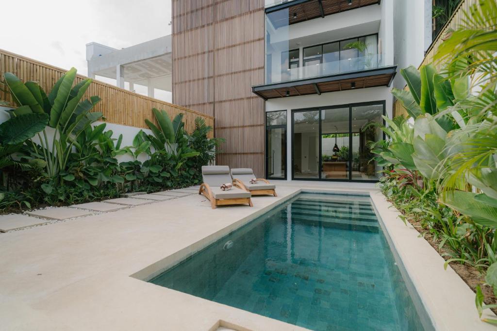 a house with a swimming pool next to a building at Modern 3BR Private Pool Villa 5-min Beach in Canggu