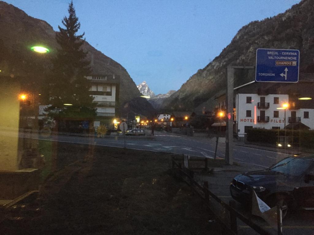 a street at night with a street sign and mountains at Albergo La Grolla in Antey-Saint-André