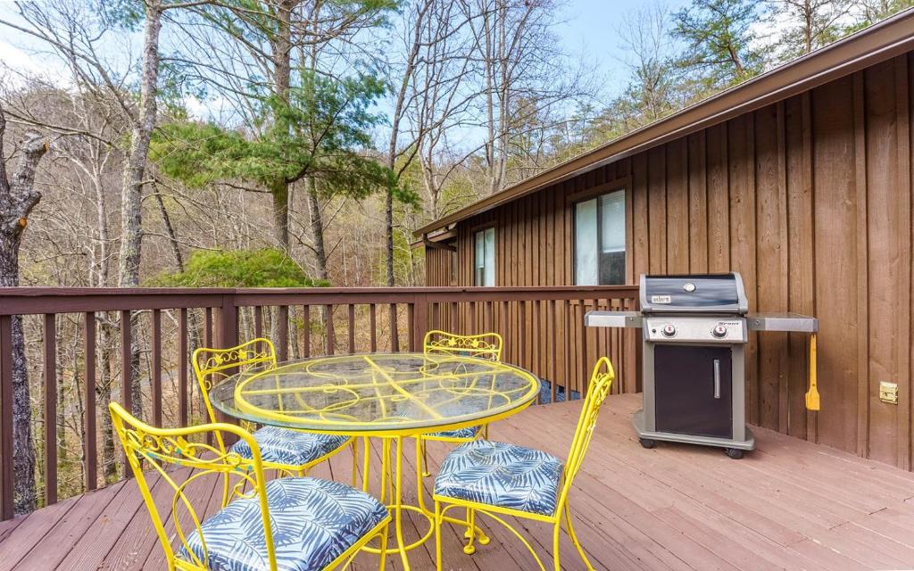a patio with a table and chairs on a deck at Cottage On The Ridge in Sevierville