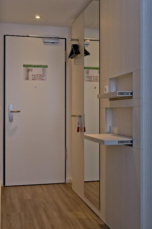 a door leading into a kitchen with a counter and a desk at Super 8 by Wyndham Munich City North in Munich