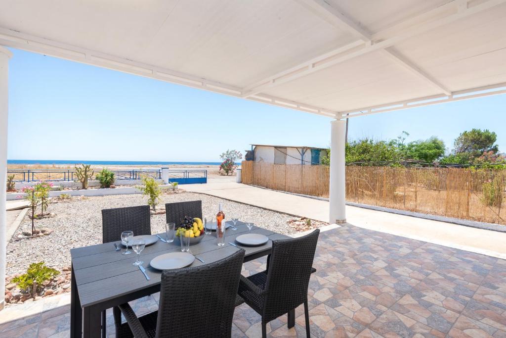 a table and chairs on a patio with a view of the ocean at PARADISE SEA HOUSE a in Haraki