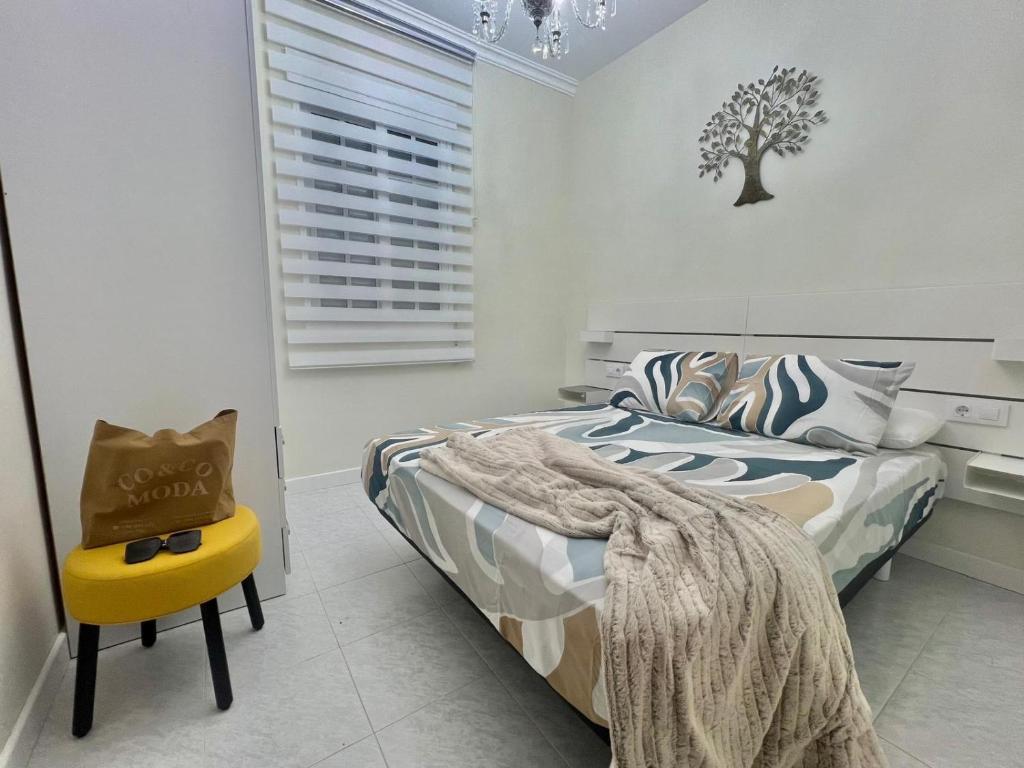 a bedroom with a bed and a yellow chair at Casa con vistas en Bueu in Bueu