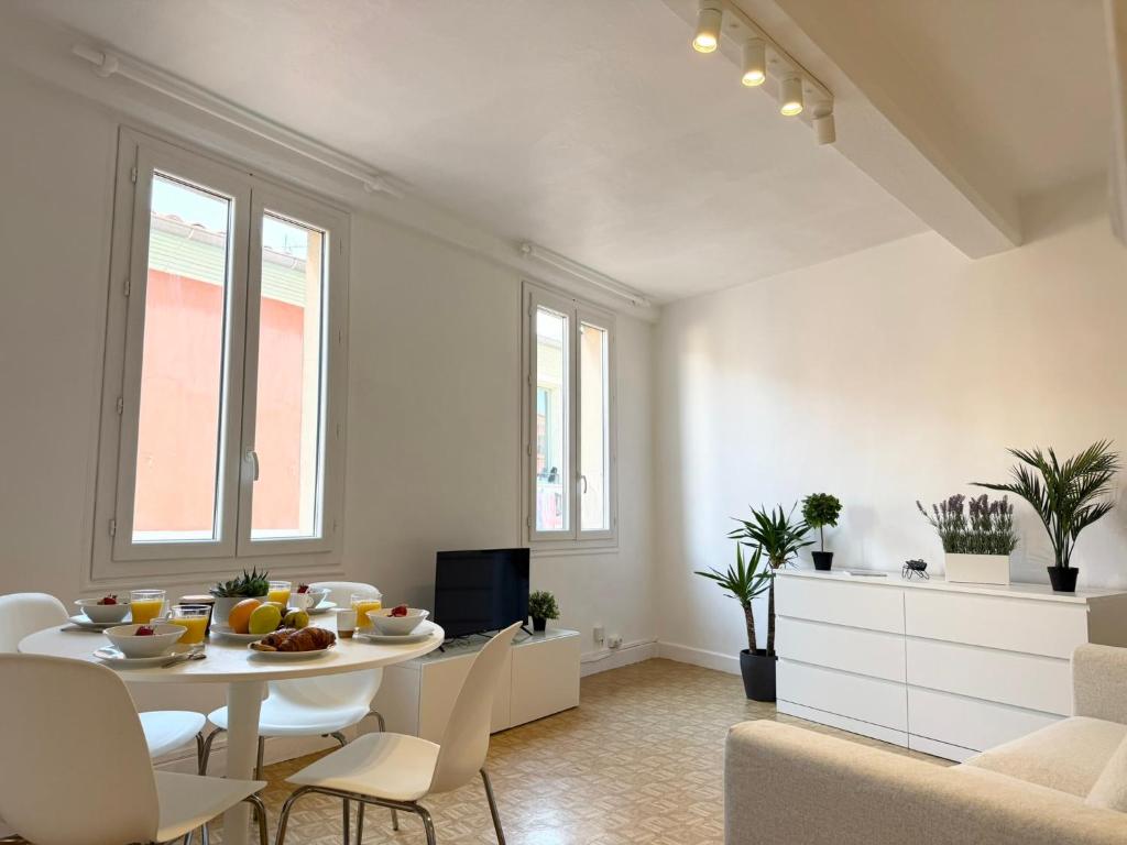 un salon blanc avec une table et des chaises dans l'établissement Charmant 2 pièces proche mer, à Nice