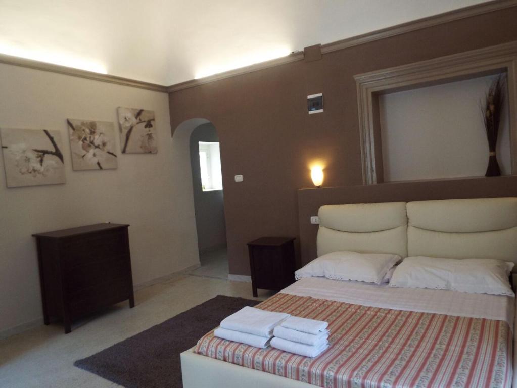 1 dormitorio con 1 cama con toallas en Cusmano Residence, en Catania