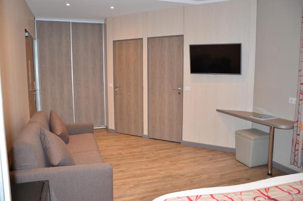 TV a/nebo společenská místnost v ubytování Brit Hotel Confort Le Revest Sainte-Maxime