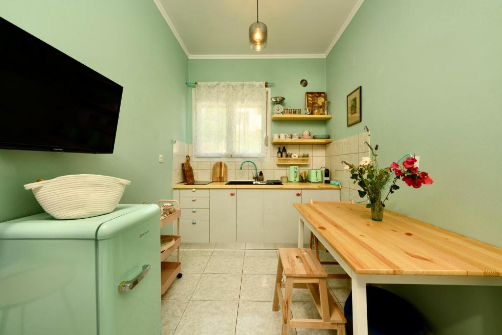 a small kitchen with a table and a refrigerator at Zoe City Home in Corfu