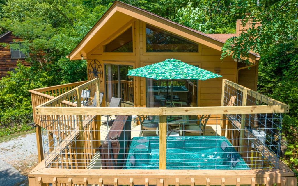 Cette maison dispose d'une terrasse avec un parasol. dans l'établissement Grand View Mountain Chalet, à Gatlinburg