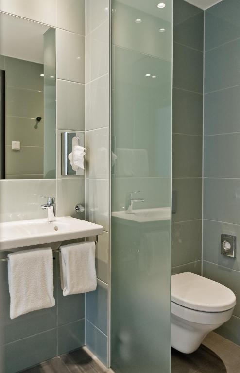 a bathroom with a toilet and a sink and a shower at Super 8 by Wyndham Munich City North in Munich