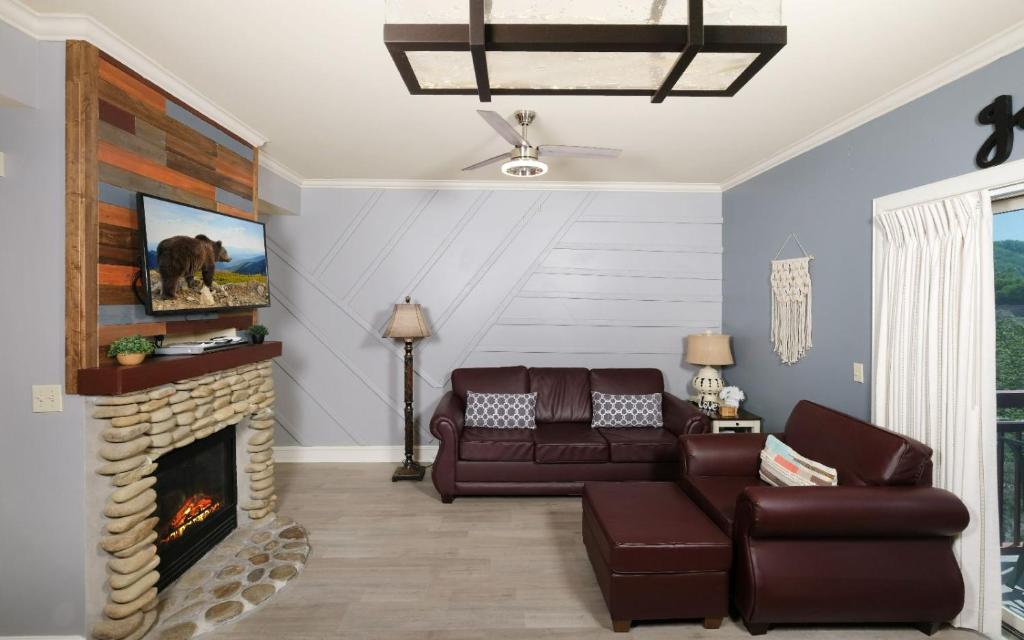 a living room with a couch and a fireplace at The Smoky Mountain Nest in Pigeon Forge