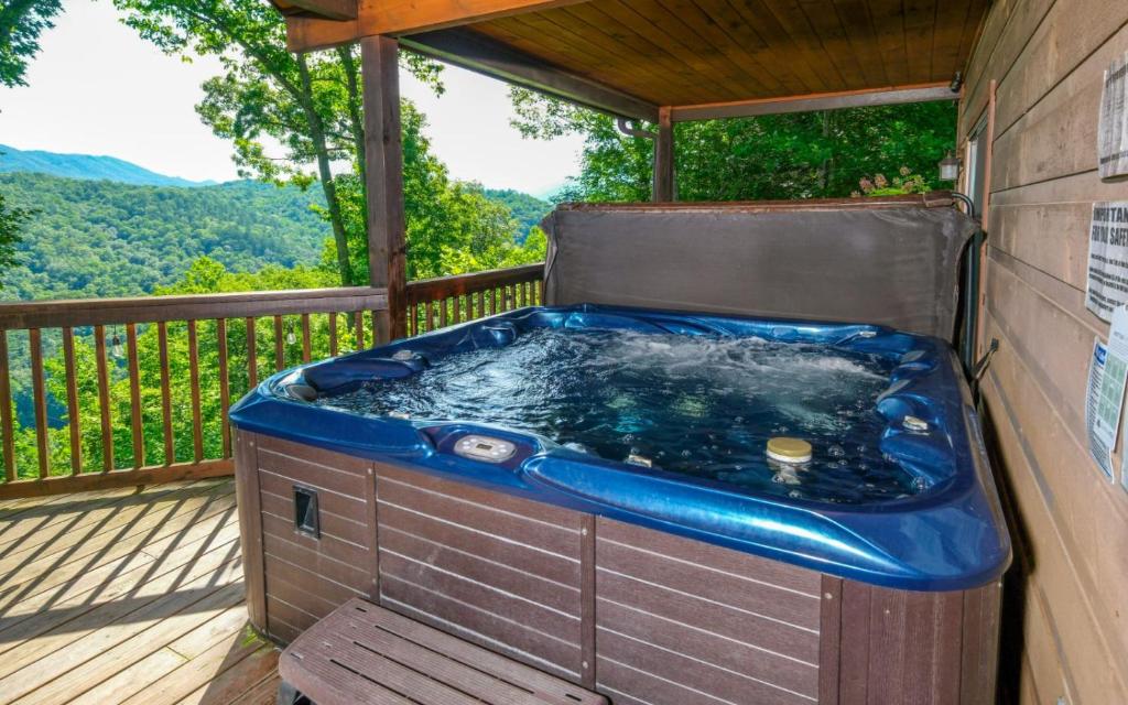 un jacuzzi en la terraza de una casa en Riversong Retreat, en Pittman Center