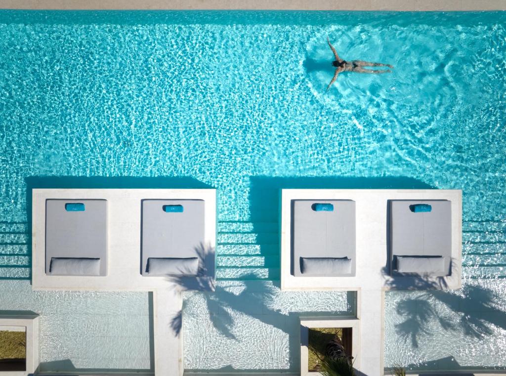 Una pintura de una persona nadando en una piscina. en Oros Luxury Beach Resort, en Georgioupolis