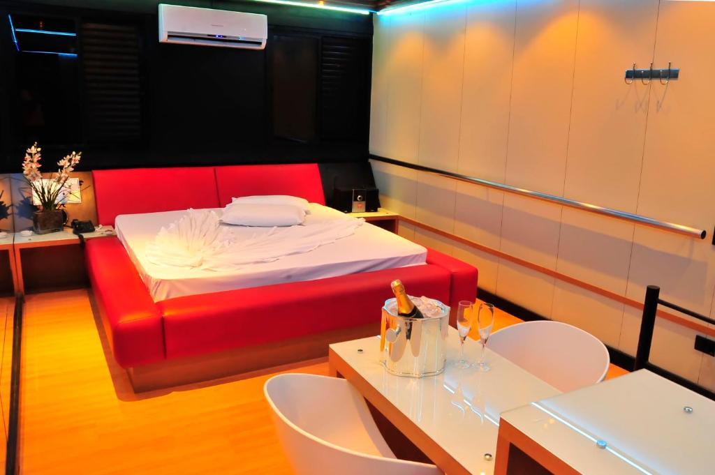 um quarto com uma cama, uma mesa e cadeiras em Motel Ritz (Adult Only) em Belo Horizonte
