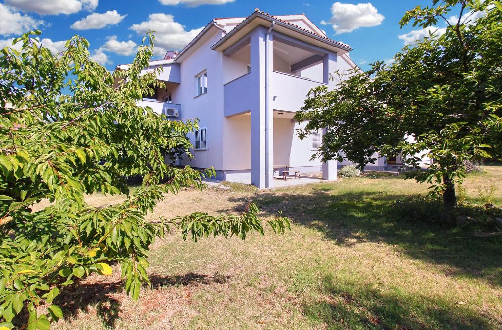 a white house with trees in front of it at Apartments Tamara 2397 in Fažana