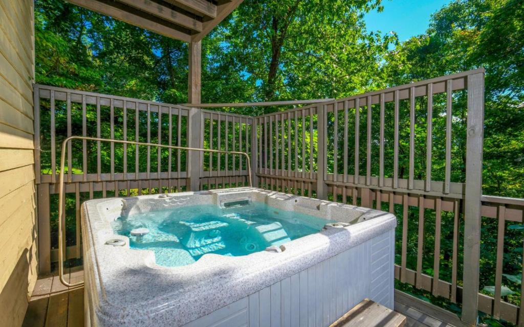 a hot tub on a deck with a fence at Coppertop View in Gatlinburg