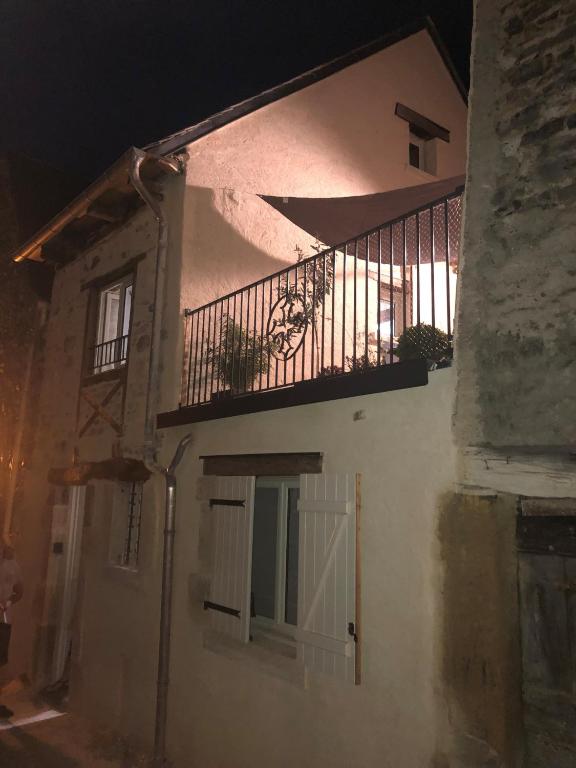 - un bâtiment blanc avec un balcon et une porte dans l'établissement La Marquise, à Saint-Côme-dʼOlt