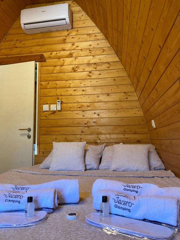 una camera da letto con un letto con asciugamani sopra di Glamping Jezero a Čačak