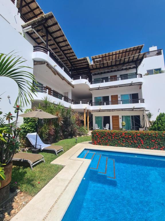 eine Villa mit Swimmingpool und ein Haus in der Unterkunft Tortugas dos cero uno in Puerto Escondido