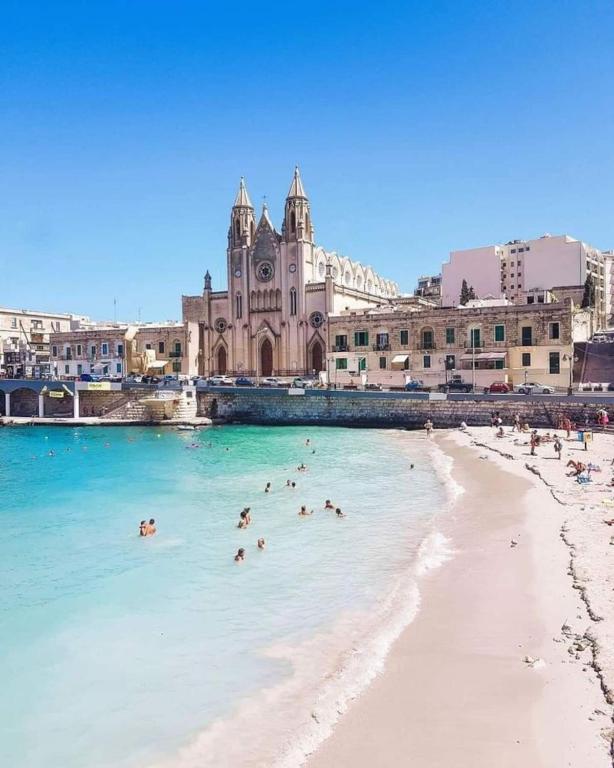 a group of people in the water on a beach at 248 Boutique Studios, Boutique Hotel, Sliema in Sliema