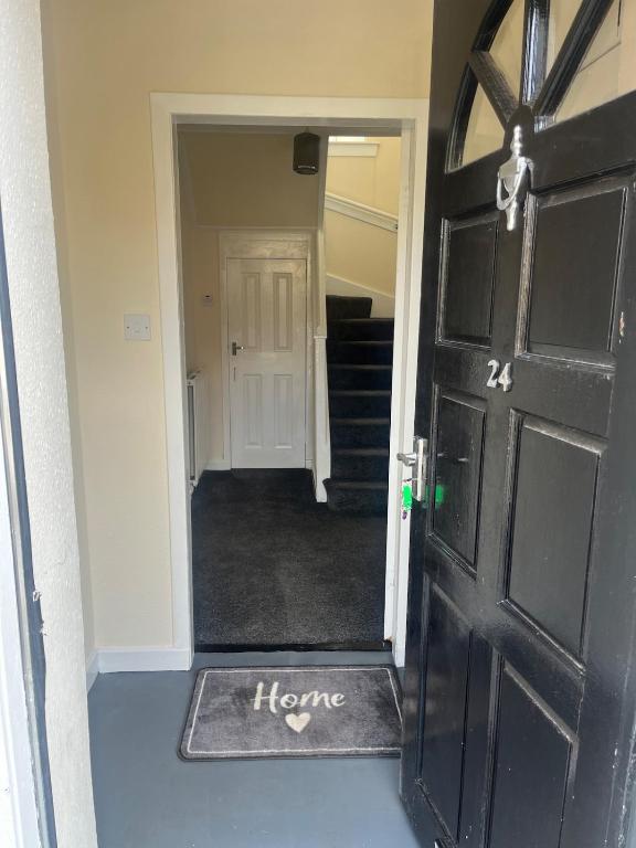 una puerta negra con la palabra hogar escrita en ella en Kirriemuir entire 3 bed house, en Moffat