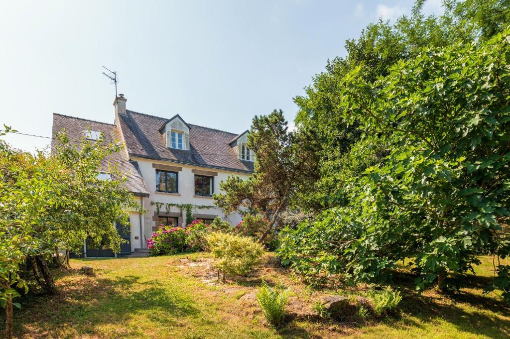 une vieille maison avec des arbres devant elle dans l'établissement Belle familiale Proche de la plage, à l'Île-aux-Moines