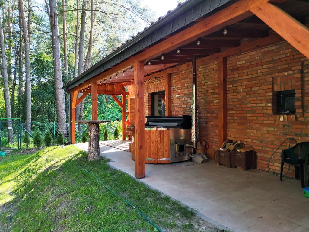 a screened in patio with a television and a brick building at Ceglany Domek z jacuzzi, nad jeziorem, przy lesie in Tomaszkowo