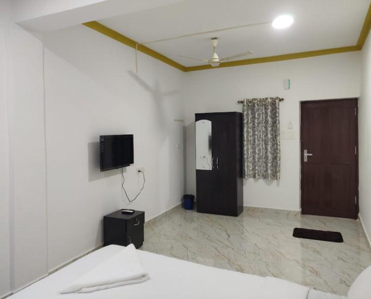a room with a bed and a tv on the wall at cbc joy resort in Calangute