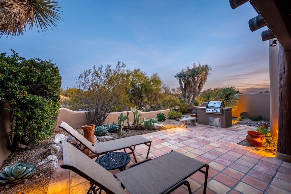 un patio avec une table, des chaises et un barbecue dans l'établissement Exclusive Boulders Retreat near Downtown Cave Creek hiking scenic views., à Cave Creek