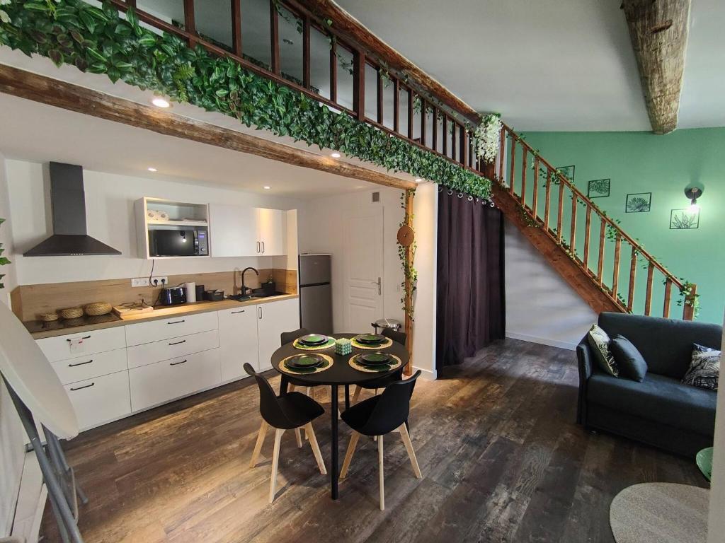 un salon avec une table et une cuisine dans l'établissement Appartement Jungle climatisé Centre Ville, à Nîmes