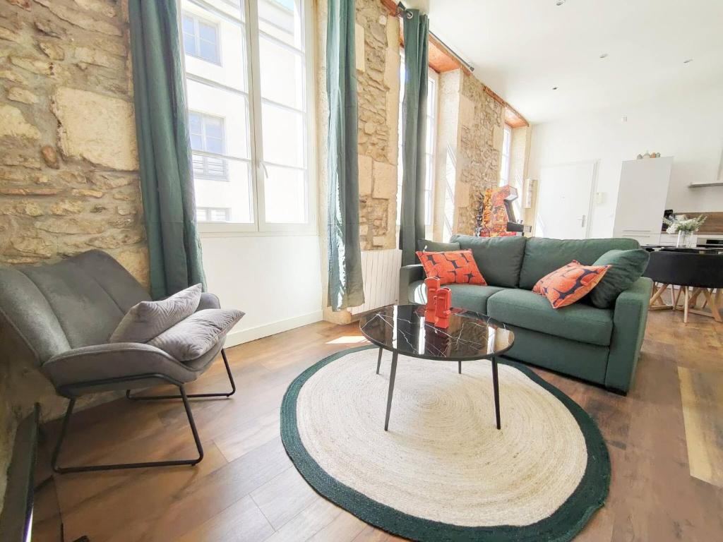 un salon avec un canapé vert et une table dans l'établissement L'ARCADIA 4 lits Climatisé Jeu d'Arcade centre historique Nîmes, à Nîmes