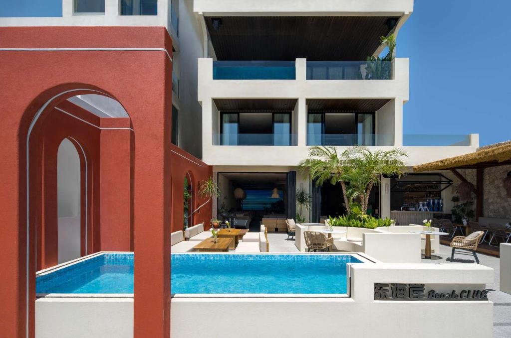 a building with a swimming pool next to a building at 深圳较场尾东海岸海景民宿 in Dapeng