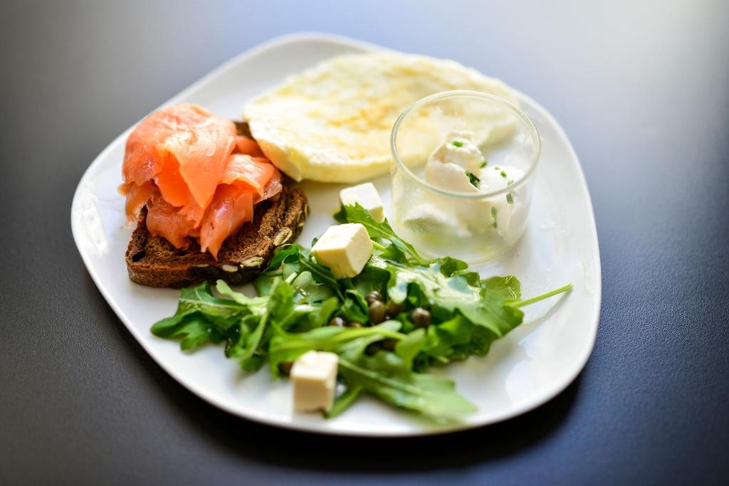 a plate of food with a sandwich and a salad at Hotel Legado Alcazar in Seville