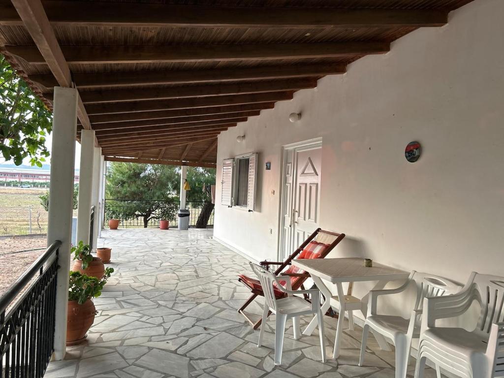 a patio with a table and chairs and a porch at Rest & Relax holiday house in Katakolo in Katakolon