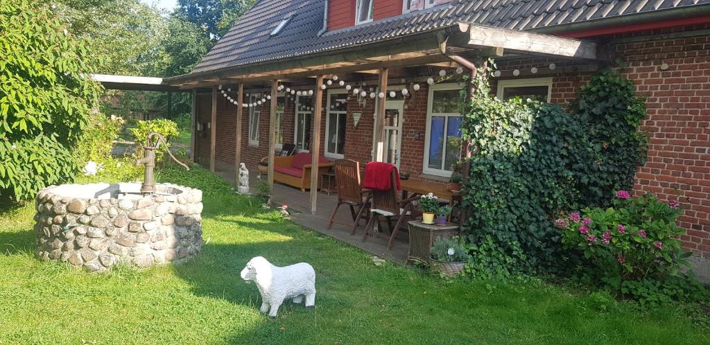 a house with a white lamb standing in the yard at Großer Stern in Stoltebüll