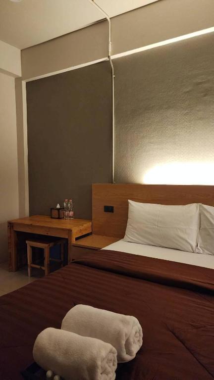 A double room with a small wooden desk, stool, and bedside tea station.