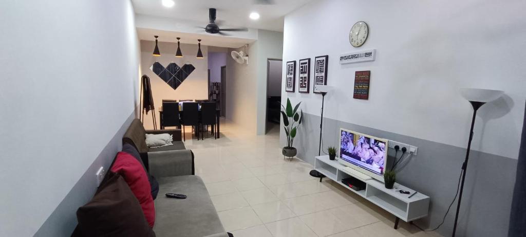 a living room with a couch and a tv at Hana Pekan Pahang Homestay 3room in Pekan