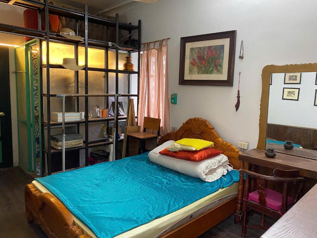 a bedroom with a bed and a desk and a table at La Maison d'art de Hanoi in Hanoi