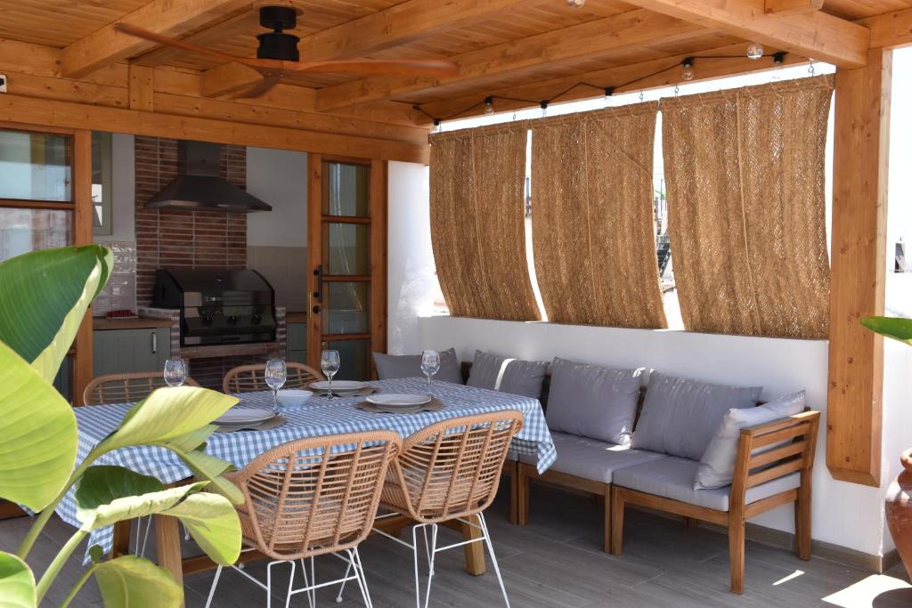 eine Terrasse mit einem Tisch, Stühlen und einem Sofa in der Unterkunft Apartamento Sol de Maro in Maro