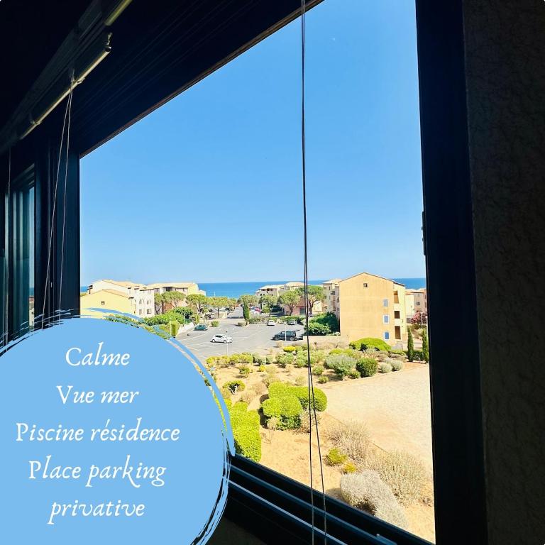 a window with a view of a parking lot at Le cosy vue mer in Fleury