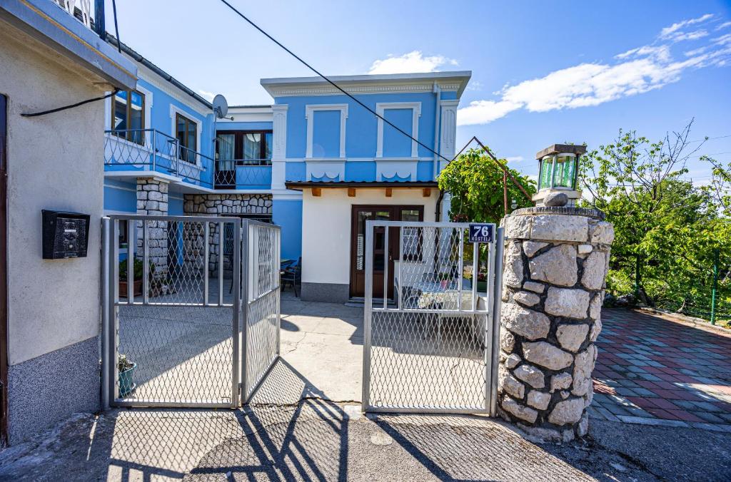 een blauw-wit huis met een poort bij MICIKA Country house in Grižane