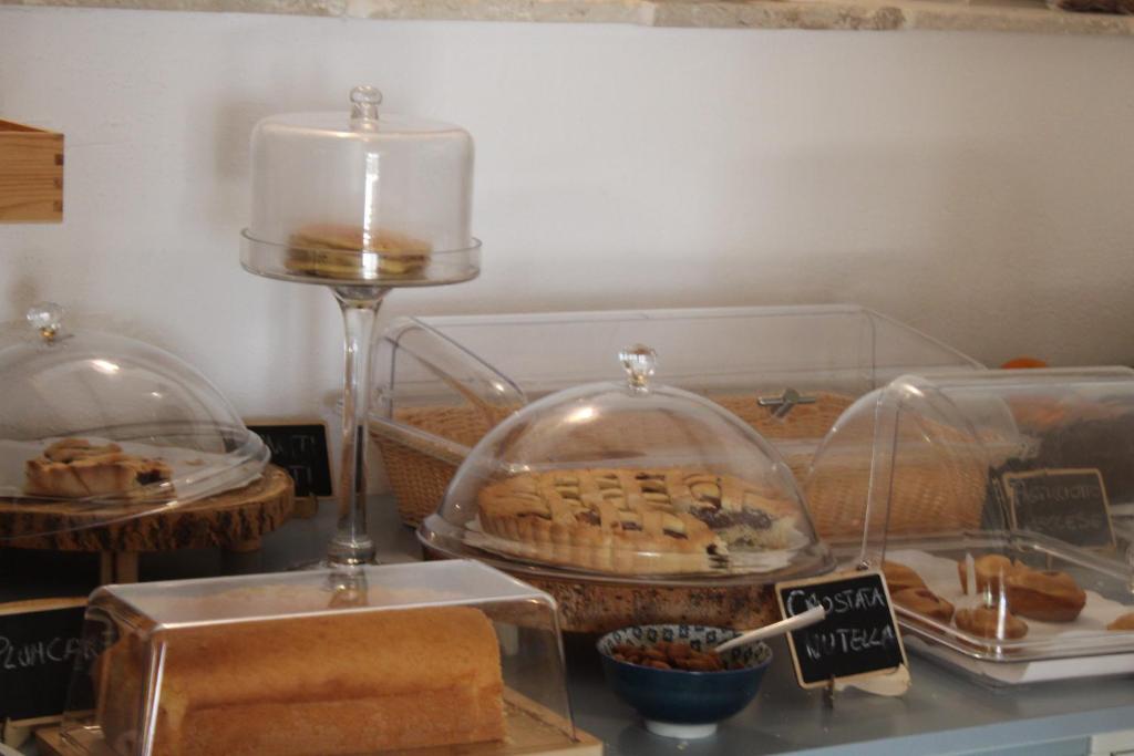a table with a candle and some food in glass domes at Masseria della Piana in Villanova di Ostuni