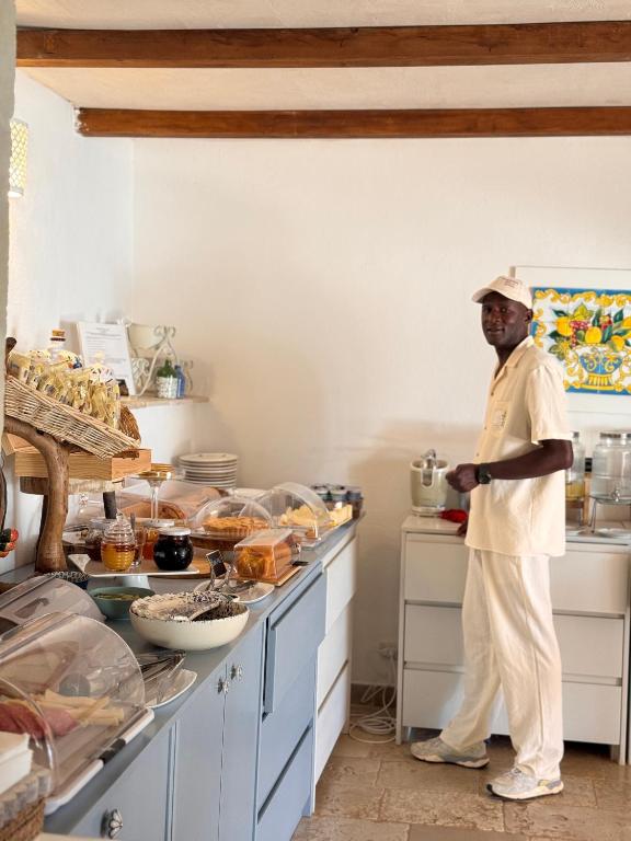 a man is standing in a kitchen at Masseria della Piana in Villanova di Ostuni